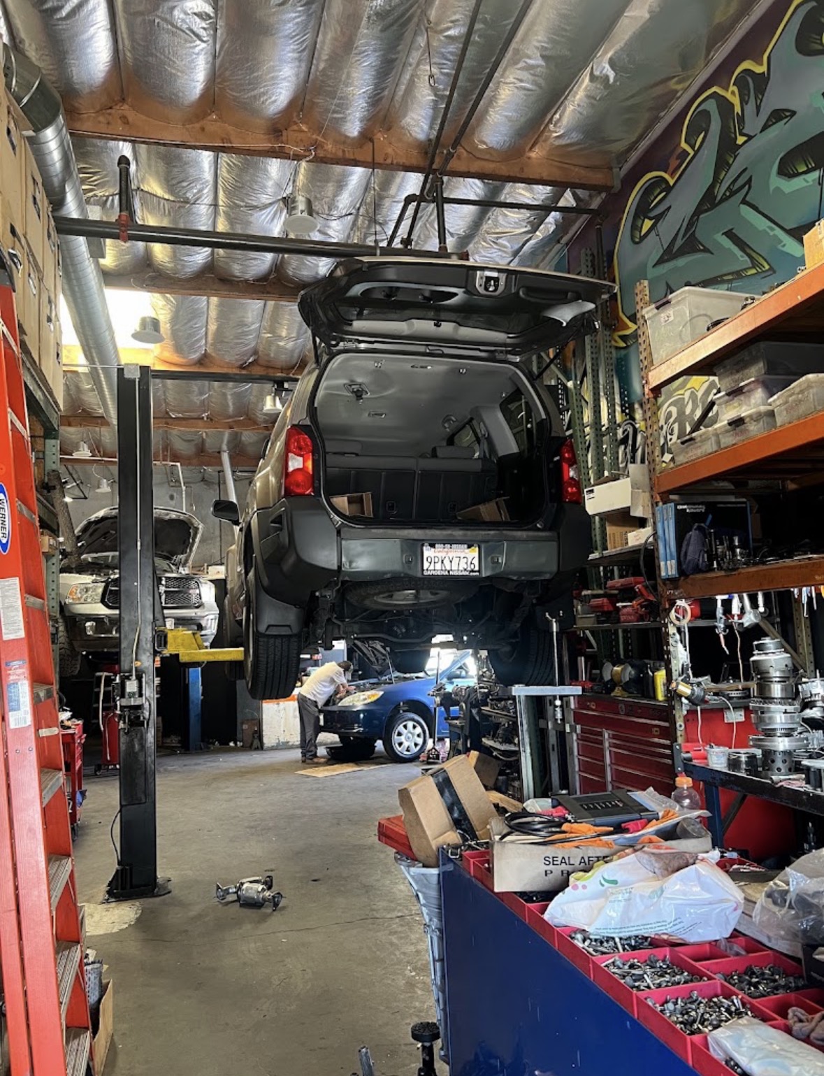 Vehicle raised on a lift inside the Transmission Plaza repair shop